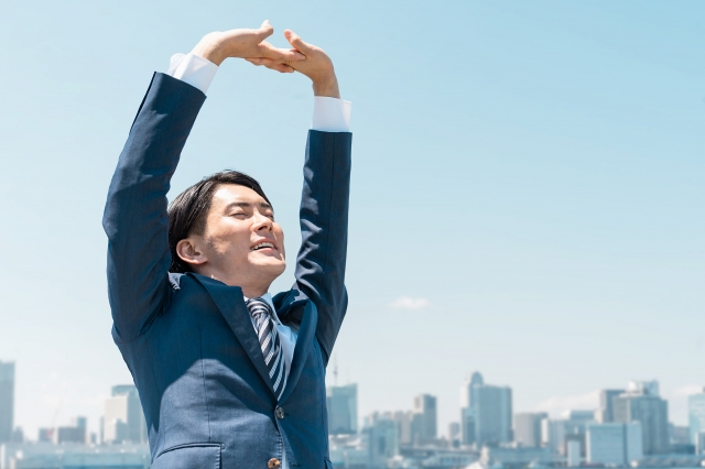 肩こりが改善して腕を上げている男性